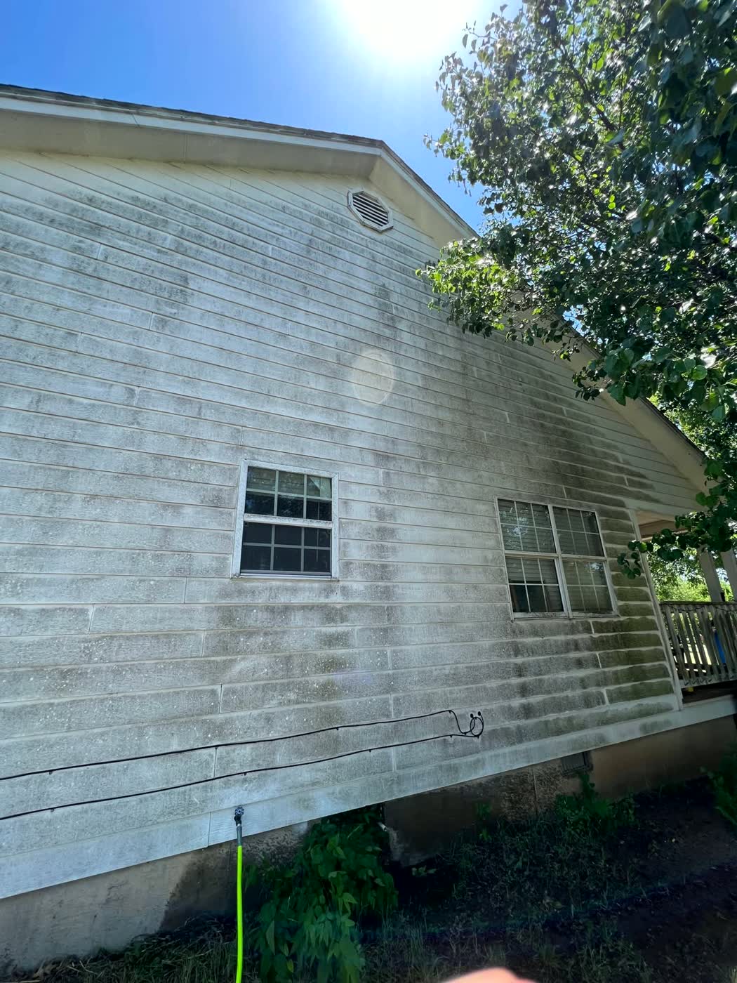 House siding covered in heavy mold and dirt before pressure washing